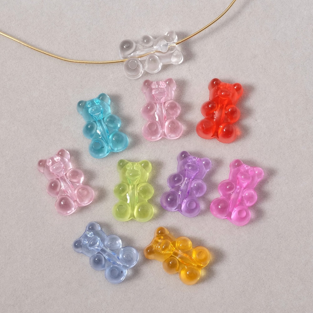 Dix perles en acrylique en forme d'oursons multicolores.