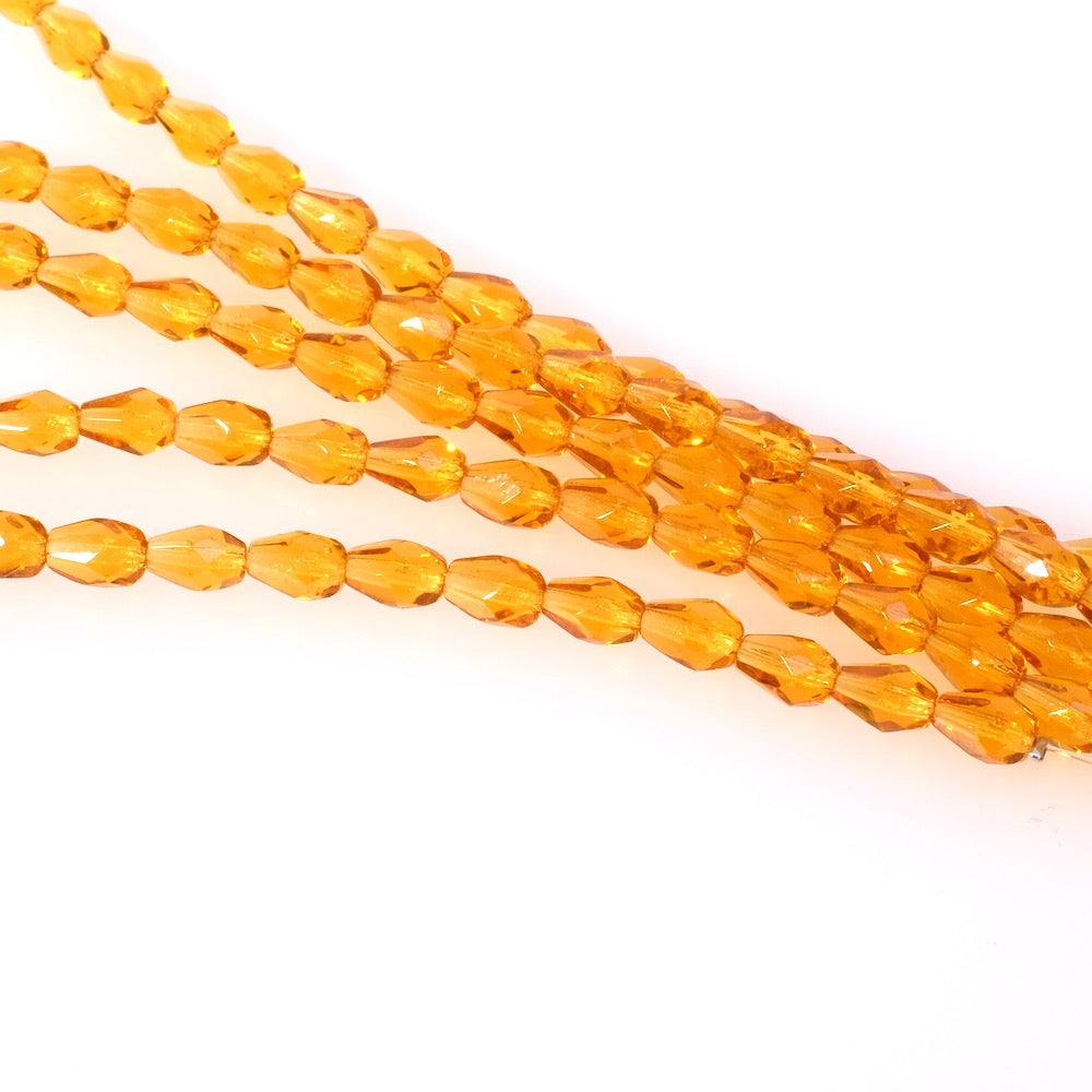 Fil de perles de Bohème gouttes 7x5mm orange miel transparent.