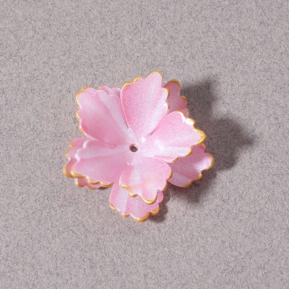Coupelle fleur double pétales en acrylique rose avec bordure dorée.