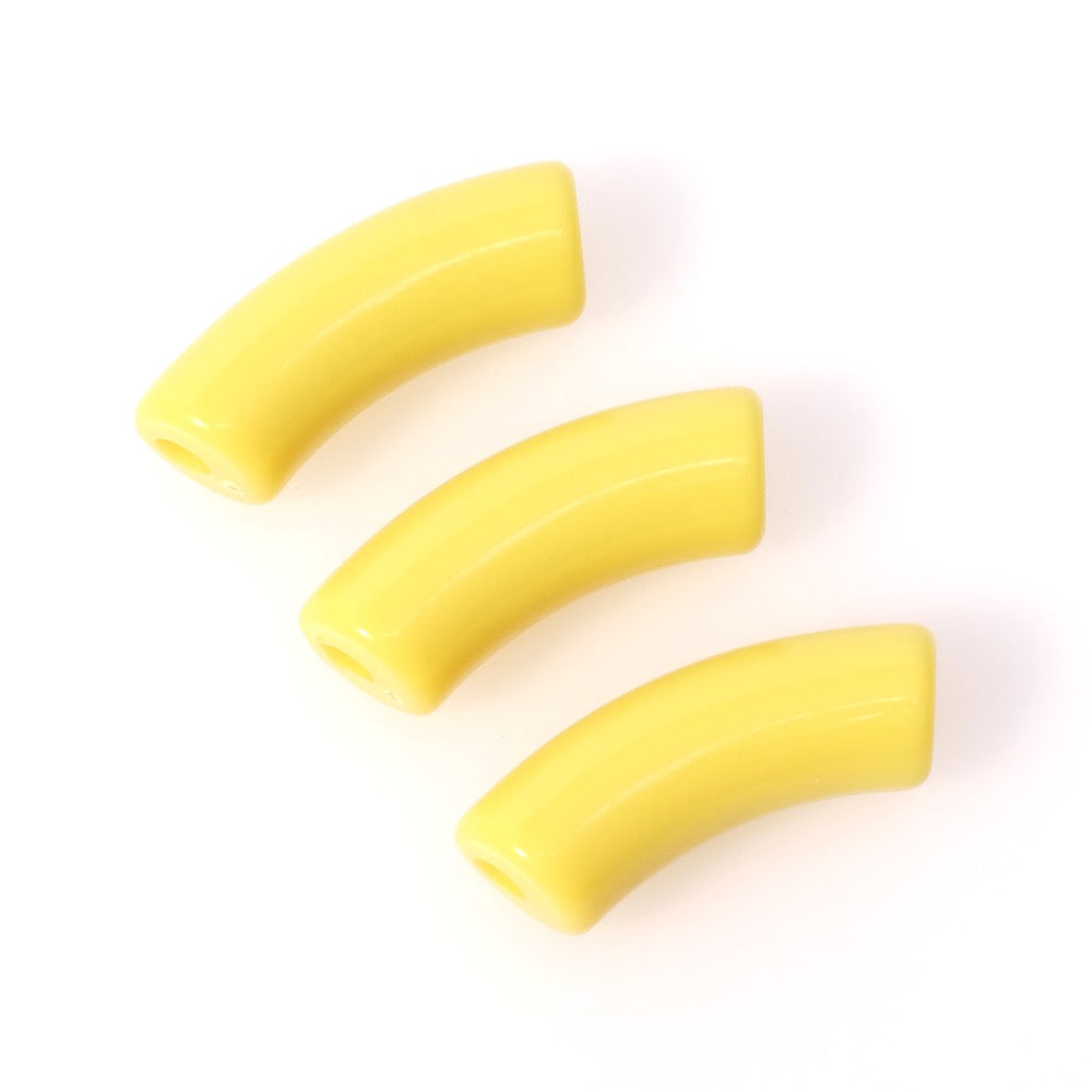 Trois perles tubulaires courbes en acrylique jaune opaque.