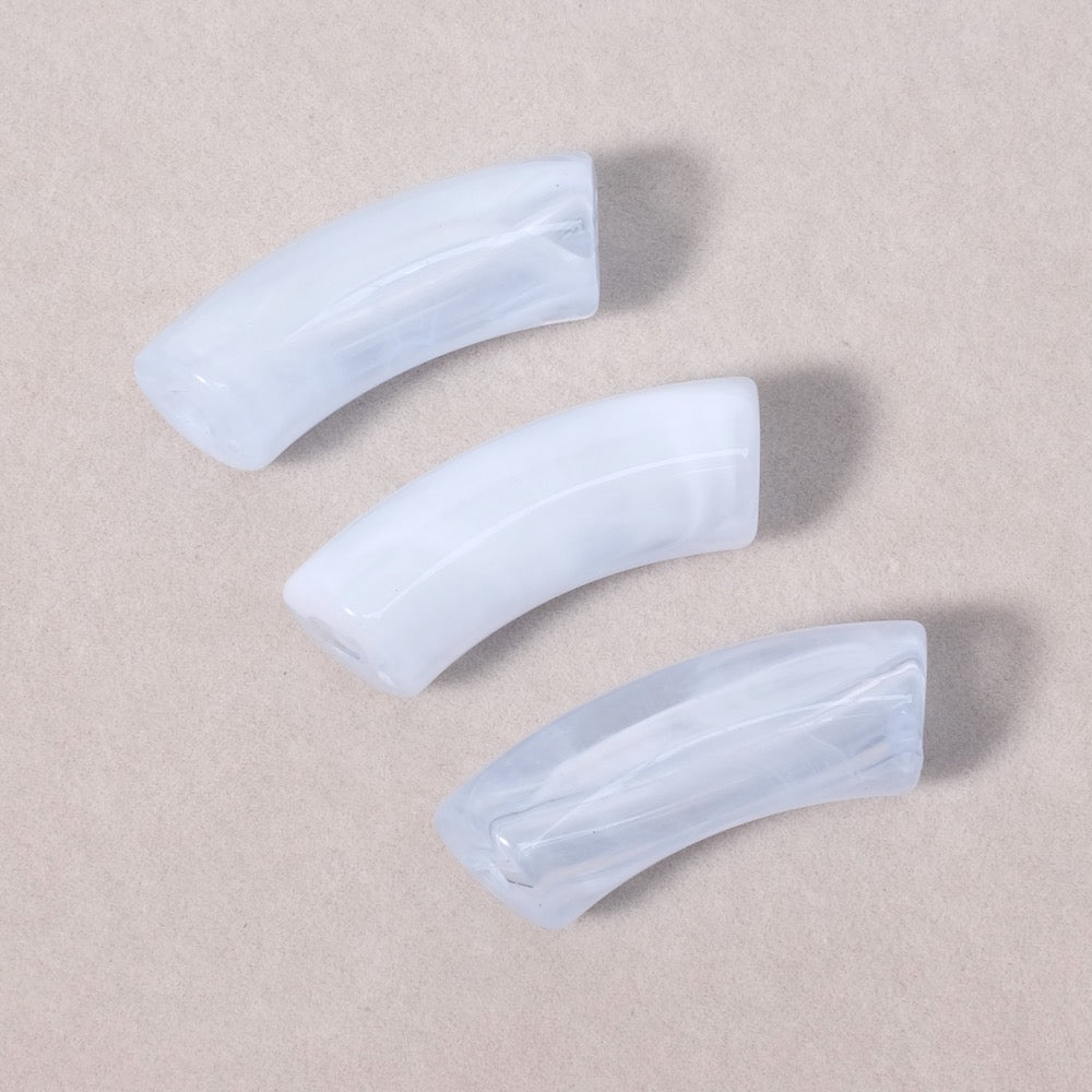 Perles tubes courbes en acrylique bleu pastel marbré semi-transparent.