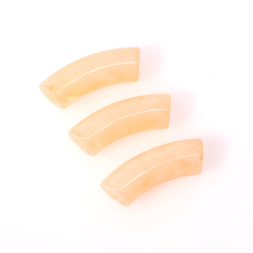 Trois perles en acrylique corail clair marbré en forme de tube incurvé.