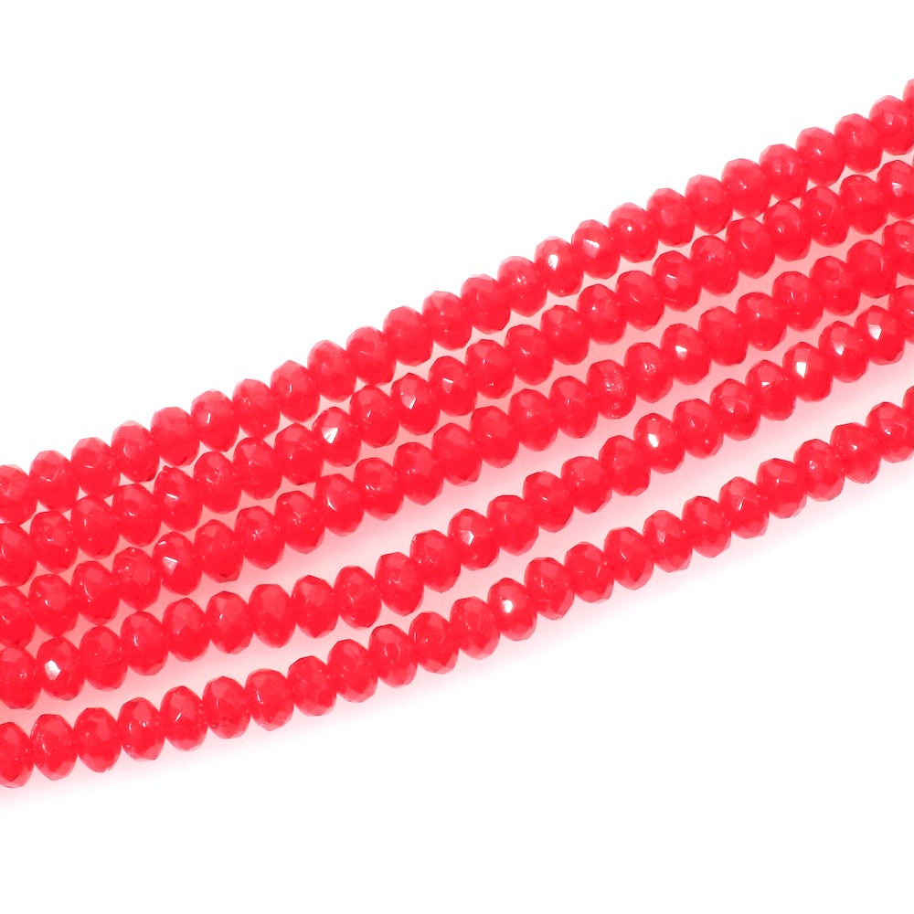 Fil de perles de verre rouge facetté en forme de donuts.