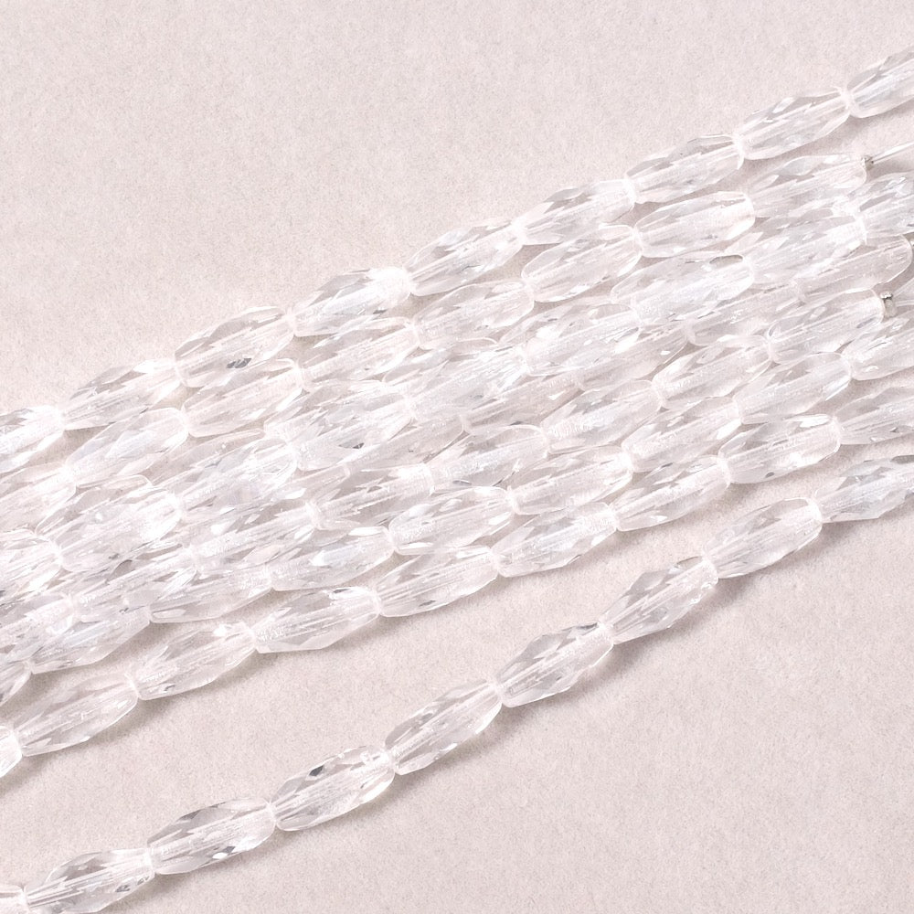 Fil de perles transparentes en verre facetté de Bohème, forme olive allongée.