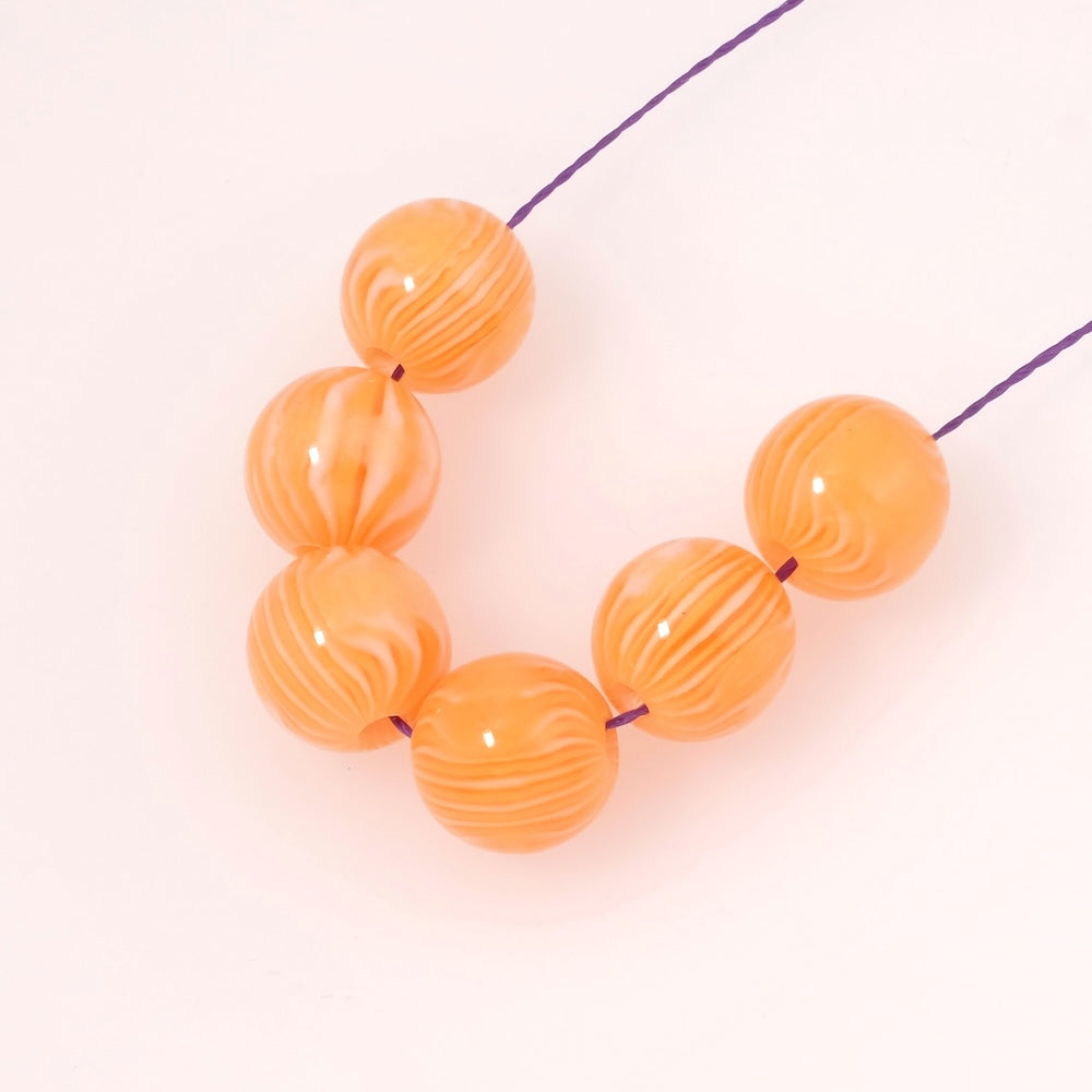 4 perles rondes en acrylique orange et blanc opaque de 12mm.
