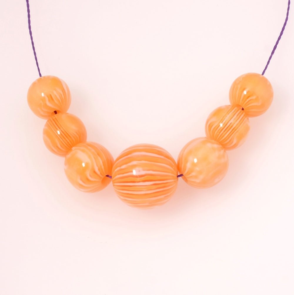 4 perles rondes en acrylique orange et blanc opaque de 12mm.