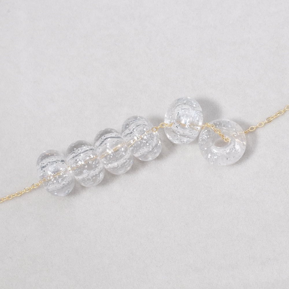 6 perles donuts transparentes en acrylique pailleté argenté de 14mm.