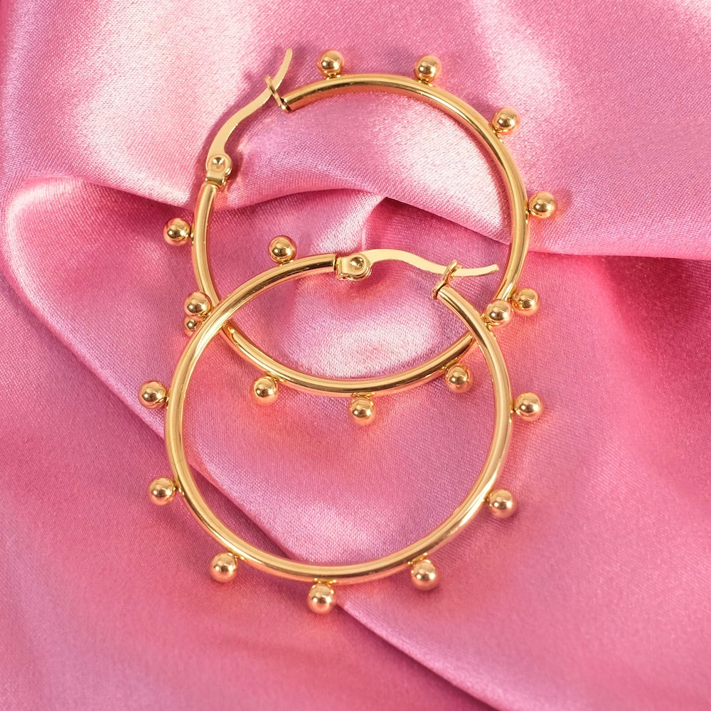 Boucles d'oreilles créoles dorées en acier inoxydable avec petites billes.