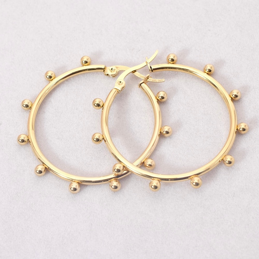 Boucles d'oreilles créoles dorées en acier inoxydable avec petites billes.