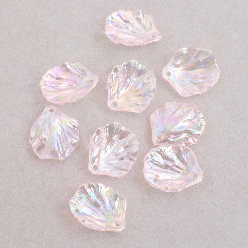 Dix pendentifs pétales de fleurs en acrylique rose transparent irisé.