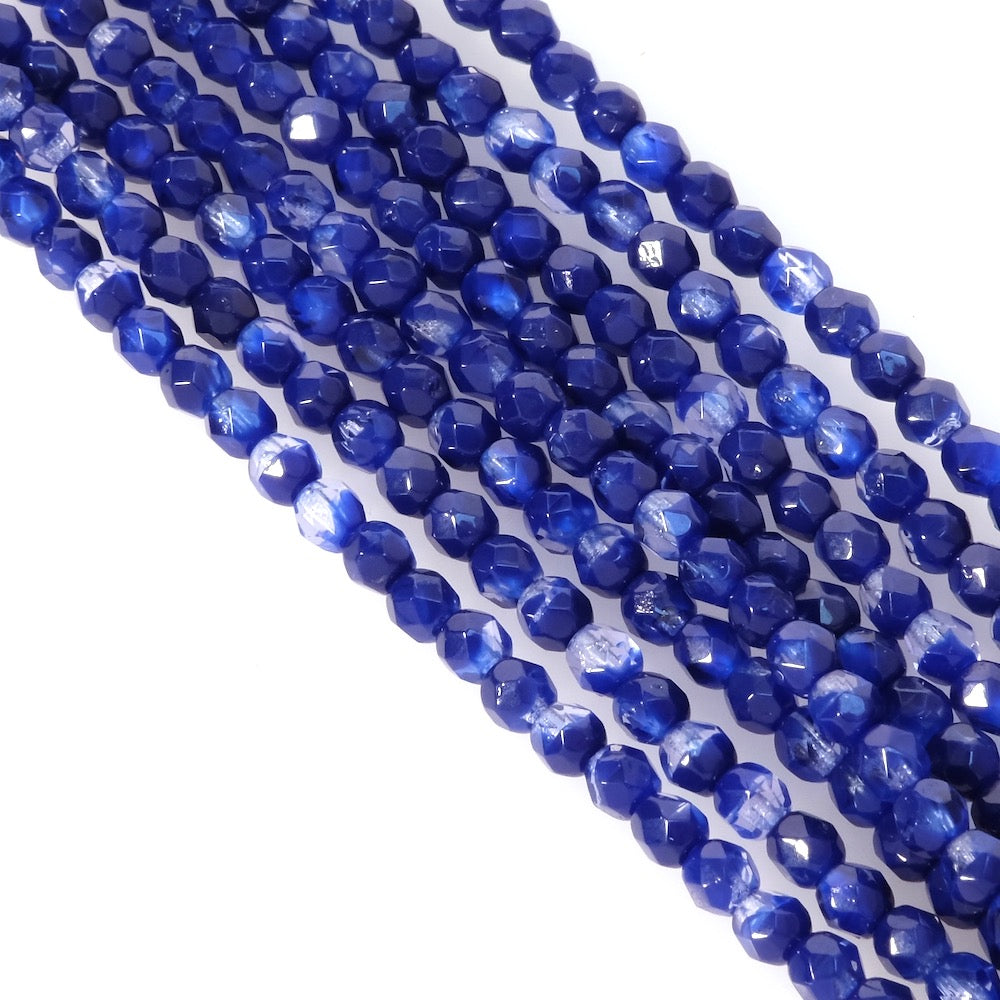 Fil de perles rondes facettées bleu nuit semi opaque de 4mm.