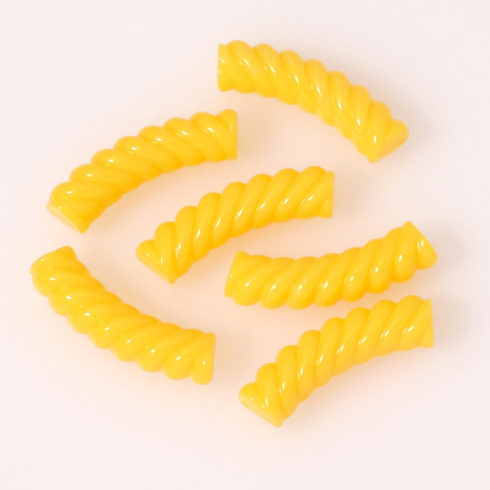 Perles tubulaires incurvées effet spirale en acrylique jaune opaque.