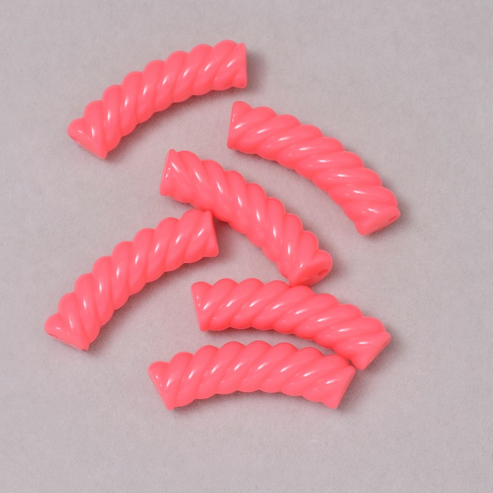 Perles tubes incurvées effet spirale en acrylique rose opaque.