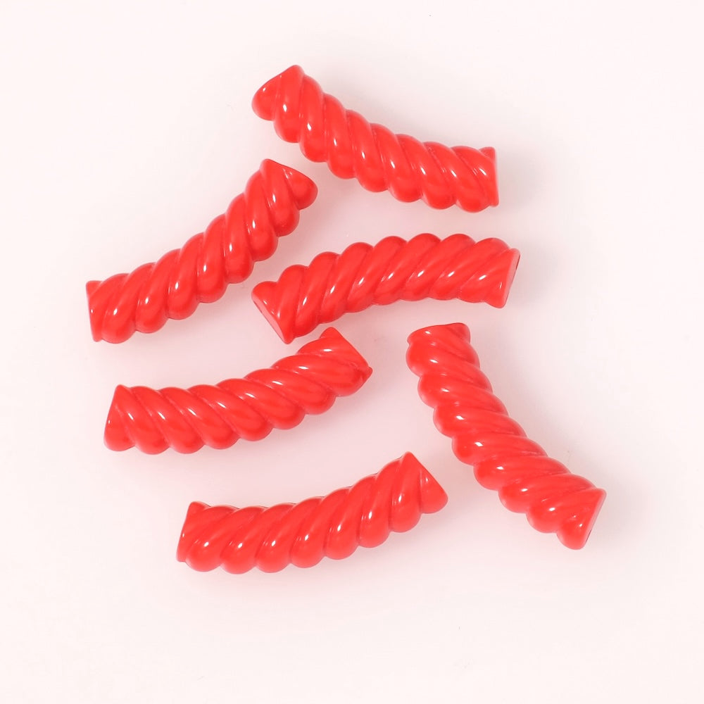 Perles tubes incurvées effet spirale en acrylique rouge opaque.