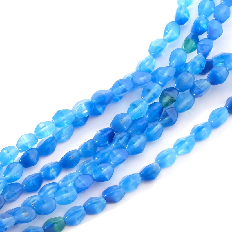 Fil de perles en verre bleu facetté en forme d'olives.