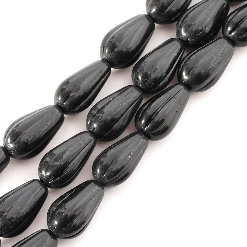 Fil de 7 perles noires en verre striées en forme de goutte.