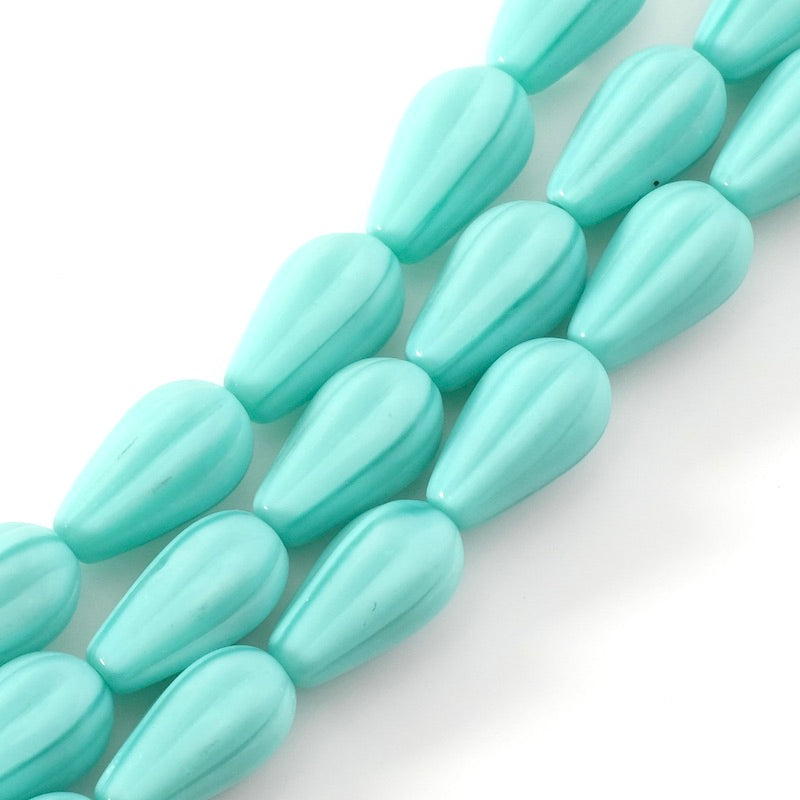 Fil de 7 perles en verre bleu turquoise strié en forme de goutte.