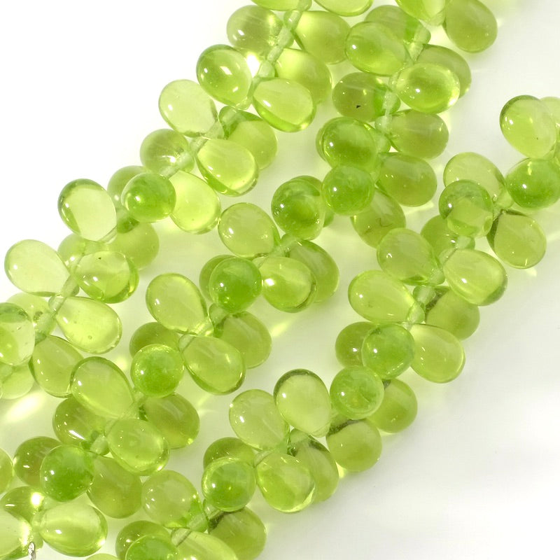 Fil de perles vertes transparentes en forme de goutte.