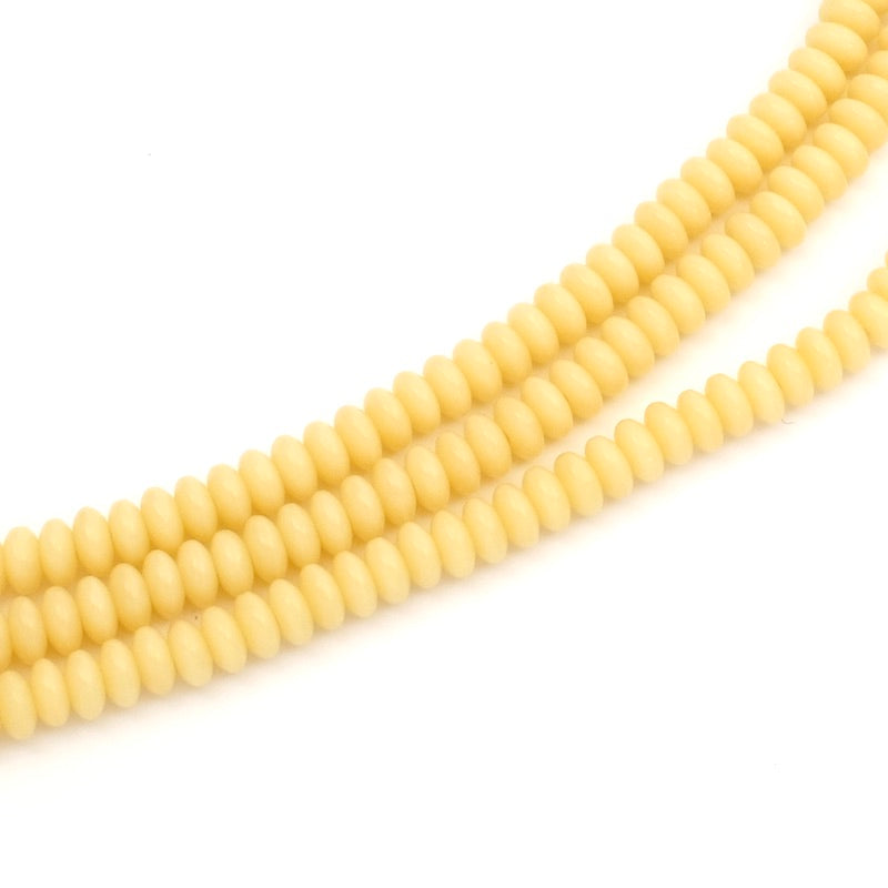 Fil de perles rondes aplaties ivoire de 2x4mm.