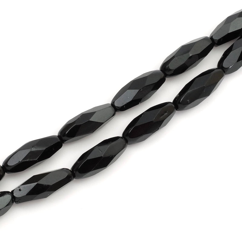 Fil de perles noires allongées à facettes de 15 x 6mm.