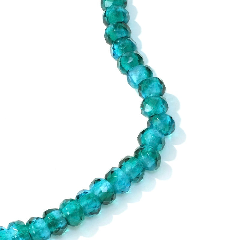 Fil de perles rondes facettées bleu canard transparent de 9x5mm.