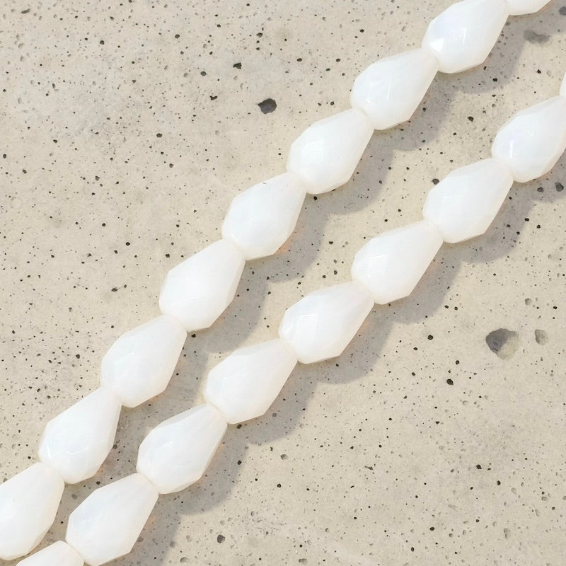 Fil de 12 perles de Bohème en verre blanc opaline en forme de goutte allongée.