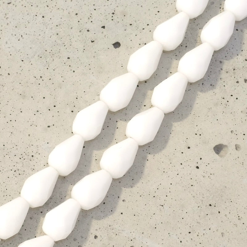 Fil de perles de Bohème en verre blanc opaque en forme de goutte allongée.