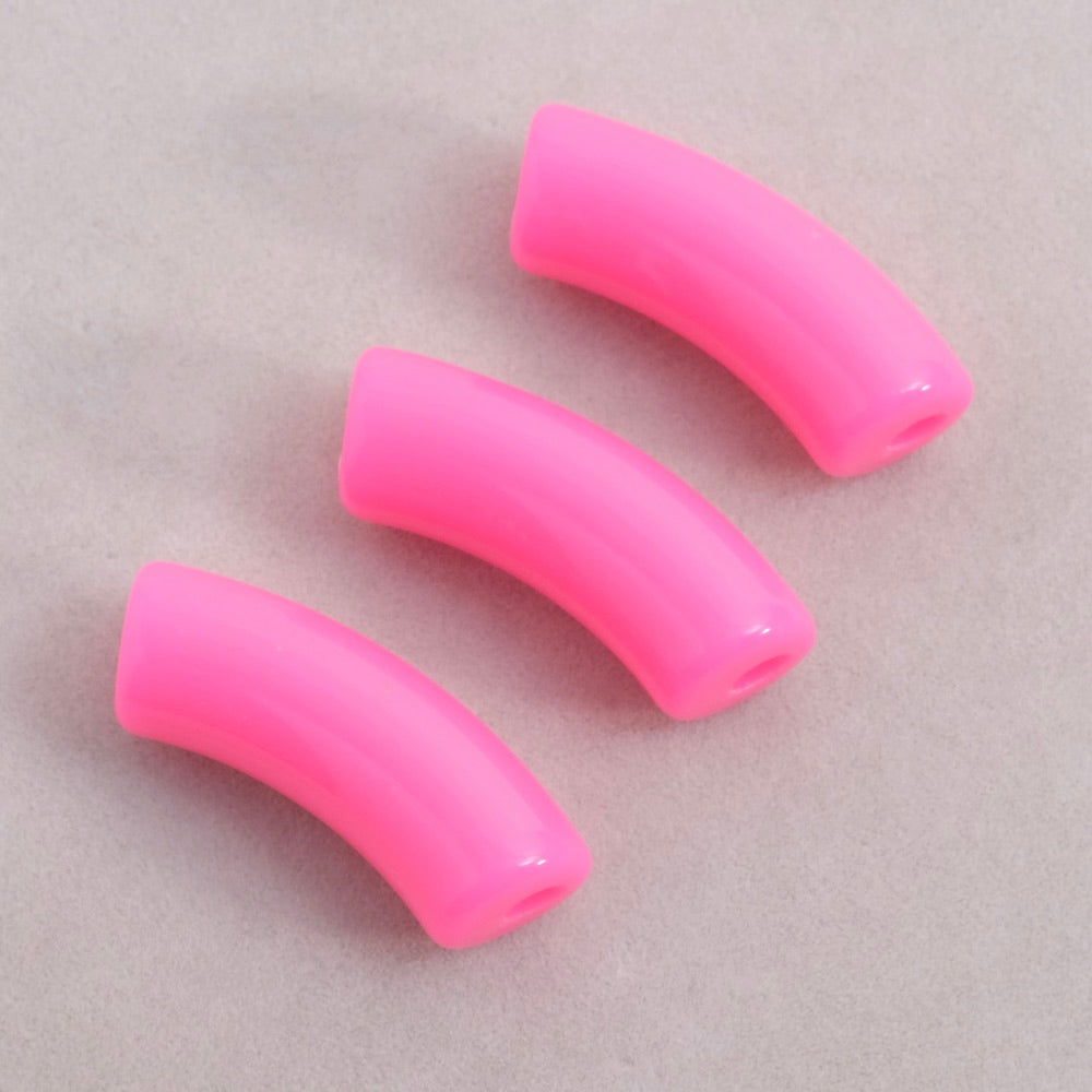 Trois perles tubulaires incurvées en acrylique rose fluo.