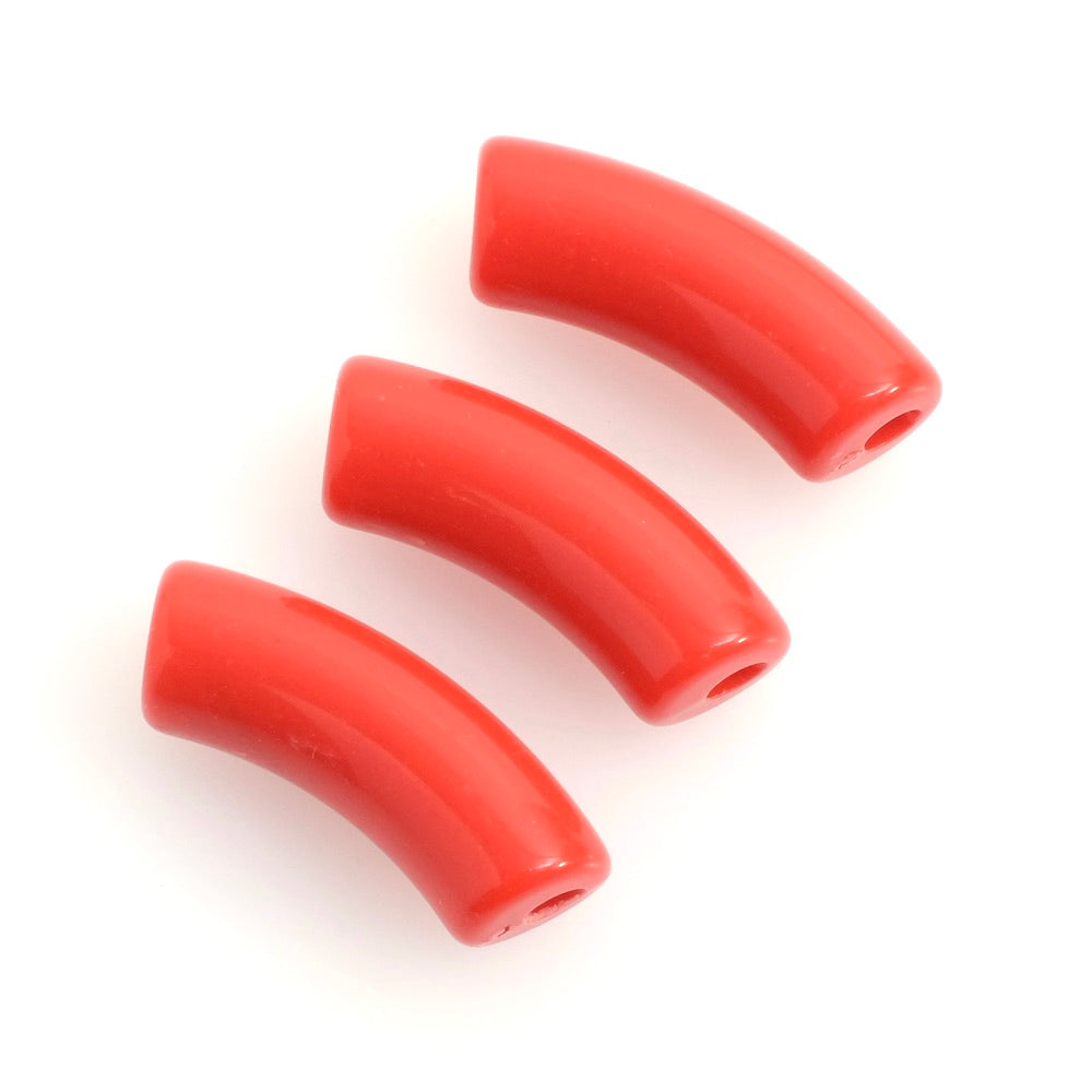 Trois perles tubulaires courbes en acrylique rouge sur fond blanc.
