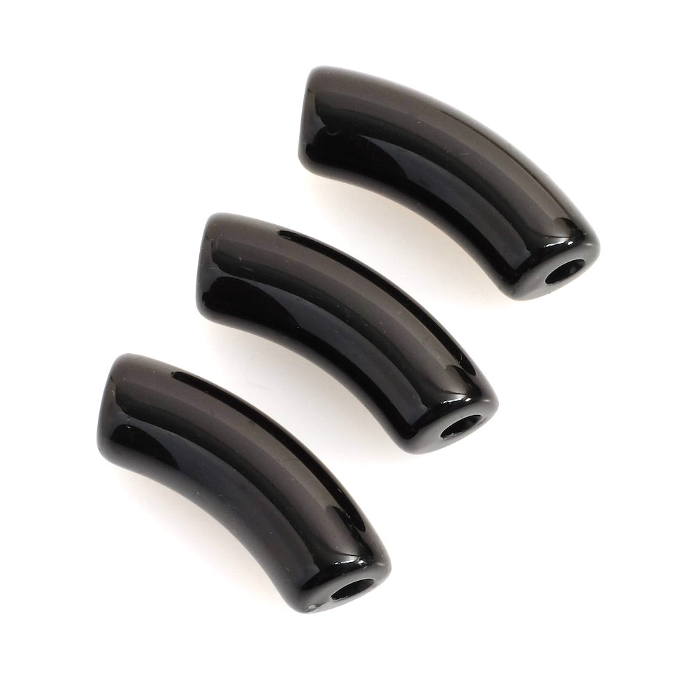 Trois perles tubulaires incurvées en acrylique noir sur fond blanc.