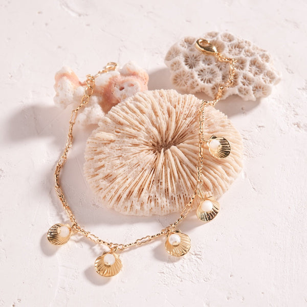 Bracelet souvenir d'été — Coquillages dorés et perles de nacre