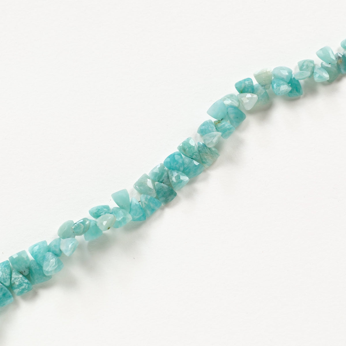 Fil de perles triangles facettées en amazonite disposé en diagonale