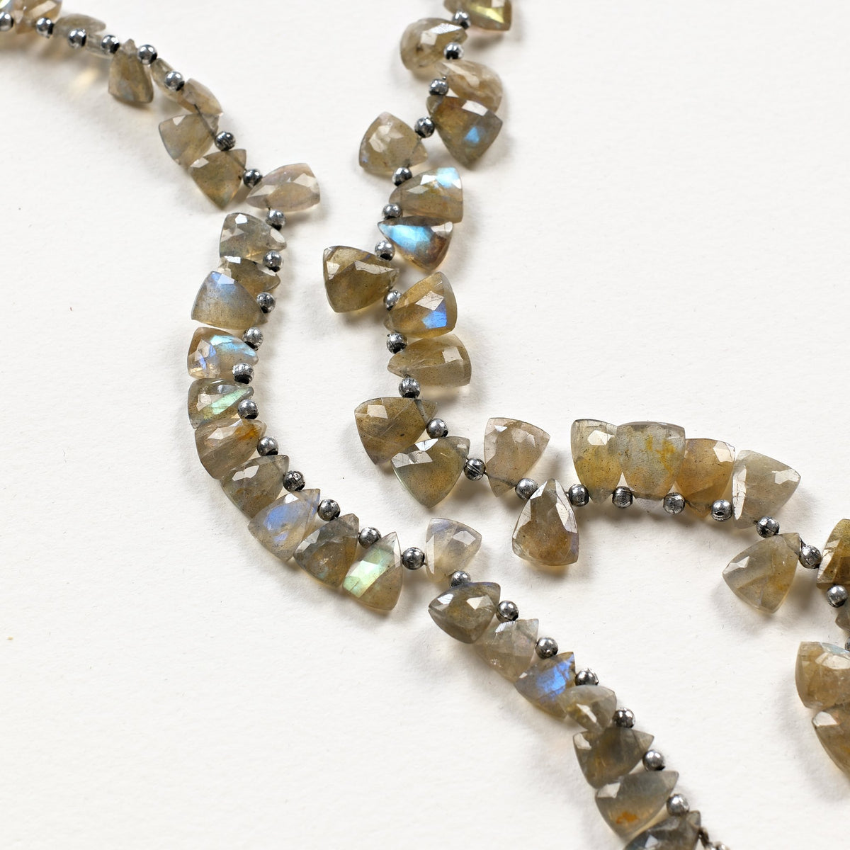 Détail de perles triangles en labradorite à la labradorescence bleue