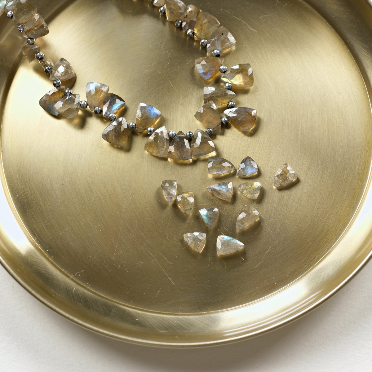 Perles triangles en labradorite naturelle sur un plateau doré