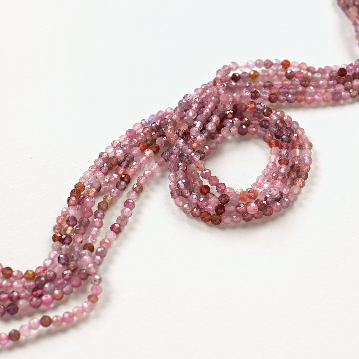 Rangs de spinelle naturel 3 mm rose et framboise formant une boucle