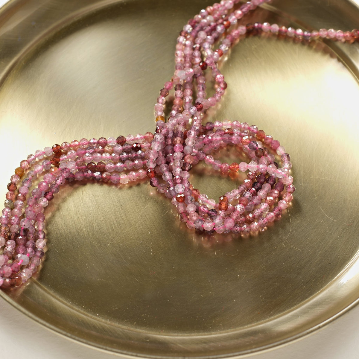 Rangs de spinelle 3 mm aux tons framboise et pêche disposés en S
