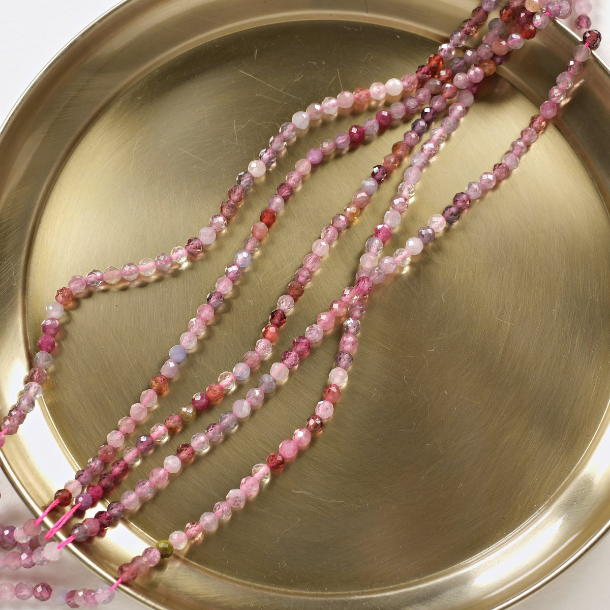 Rangs de spinelle rose et framboise 4 mm sur plateau doré