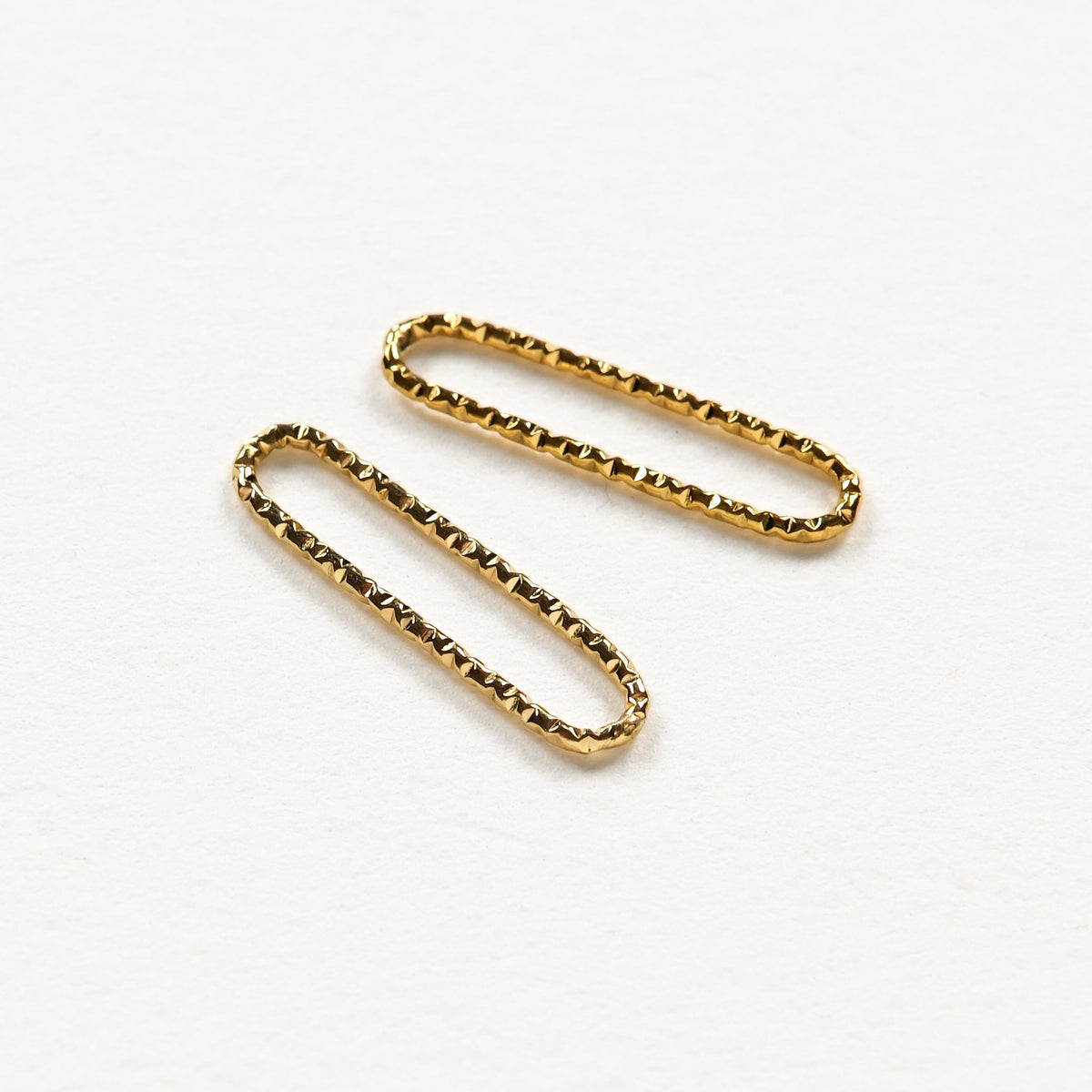Deux anneaux ovales dorés à texture scintillante diamantée