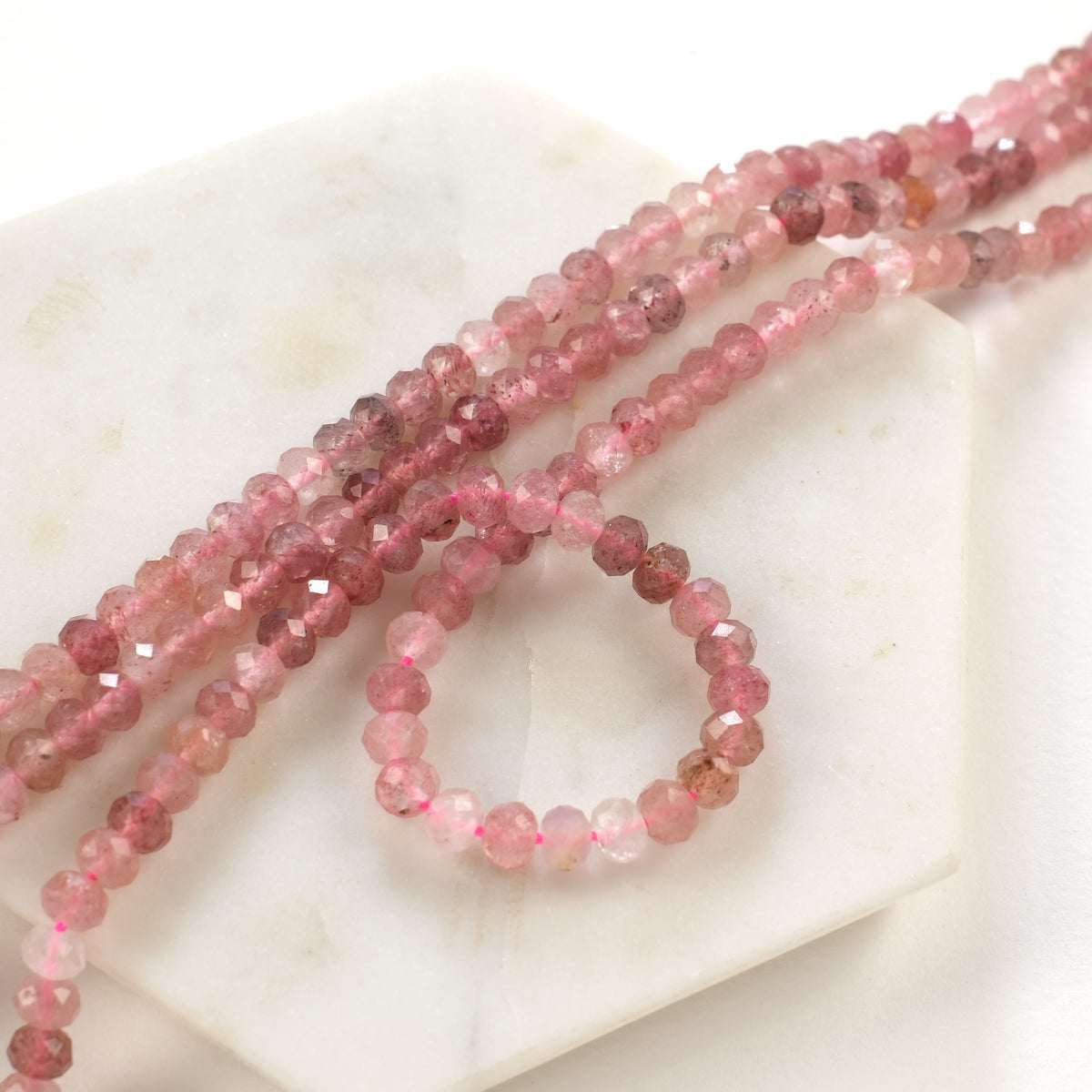Faceted strawberry quartz rondelles, close-up view