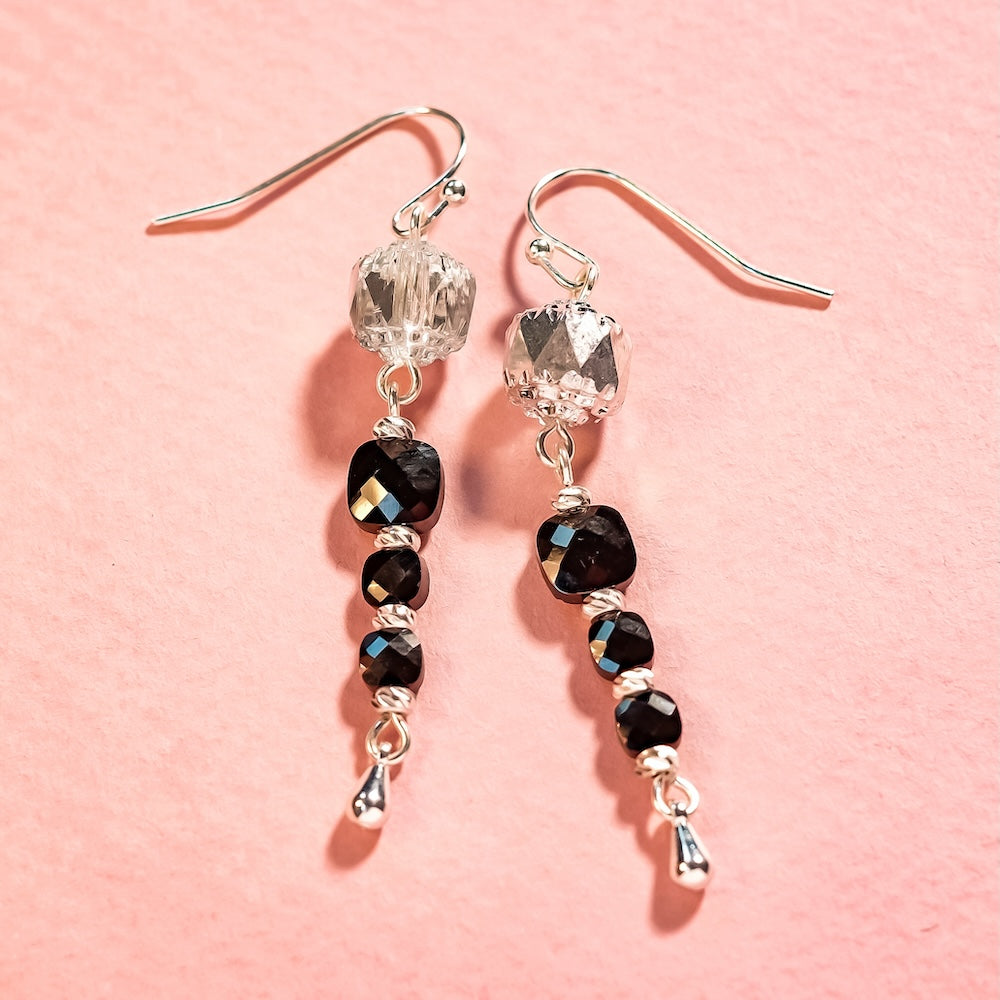 Une paire de crochets d'oreilles en argent massif 925 avec deux petites perles.