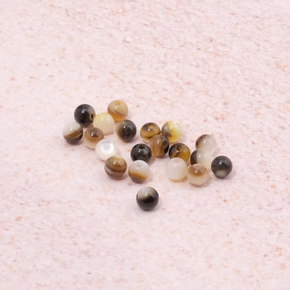 Fil de perles rondes en nacre naturelle blanche et marron.