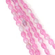 Fil de perles ovales rose et blanches à effet strié.
