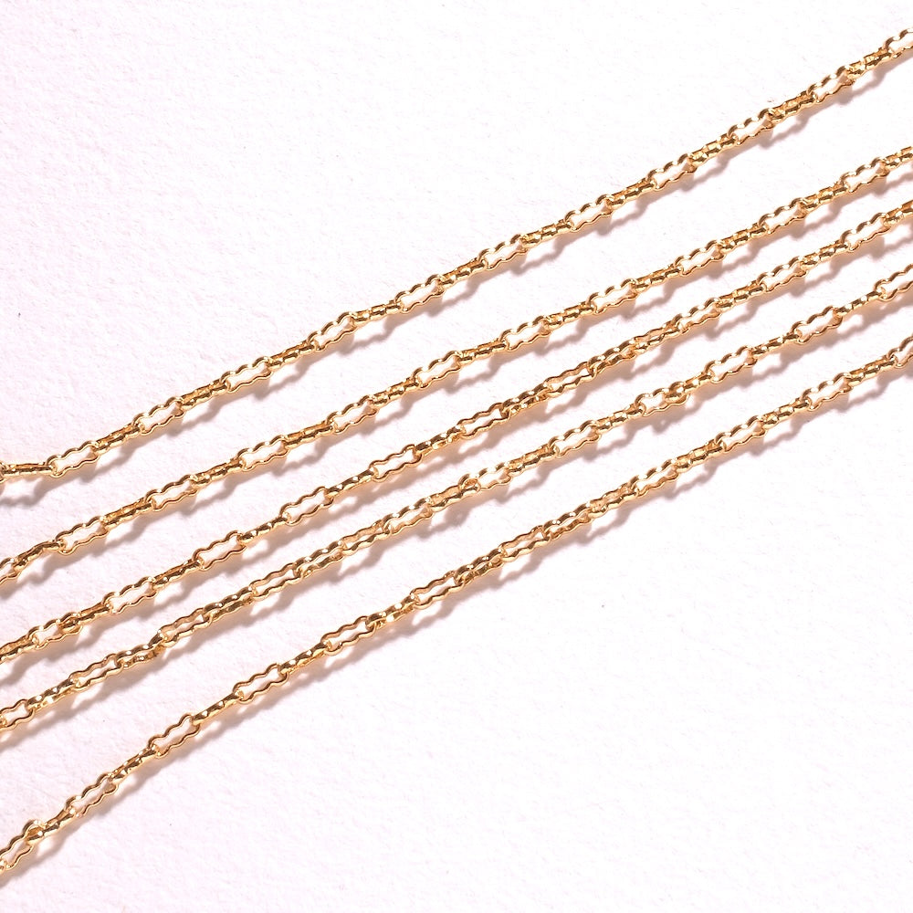 Détail des maillons ovales soudés d'une chaîne fine dorée 24K pour création de bijoux