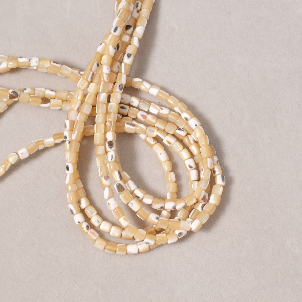 Fil de 130 perles tubes 3mm de Nacre sable