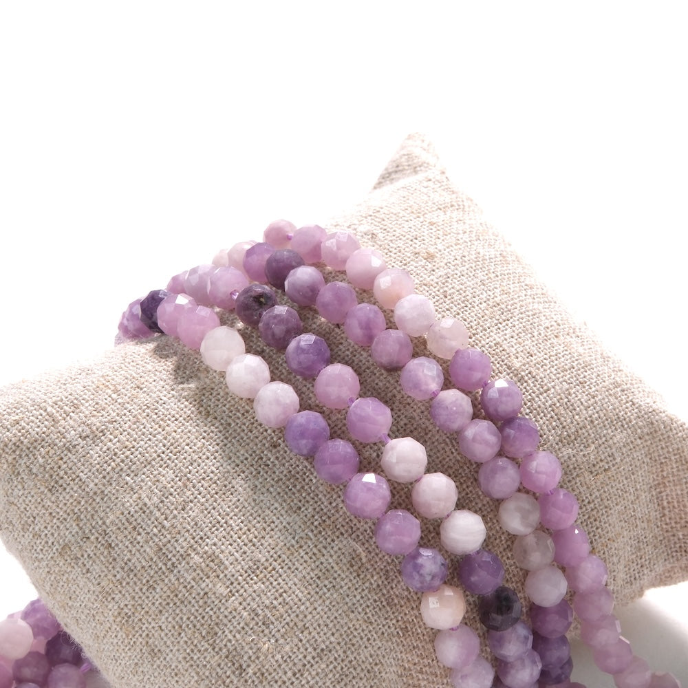 Rangs de perles en lépidolite facettées 5 mm sur coussin de lin