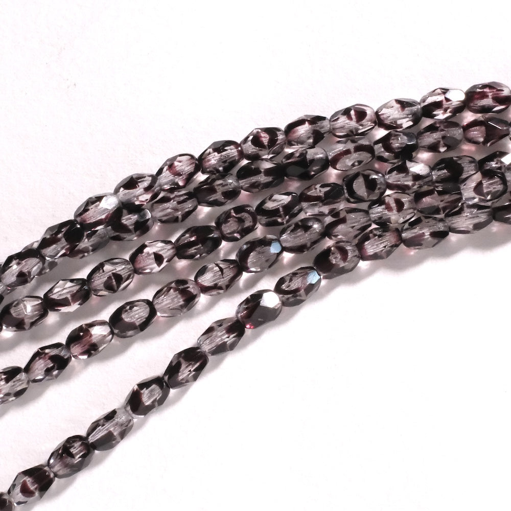 Fil de perles de Bohème ovales facettées 7x5mm Transparent tacheté violet