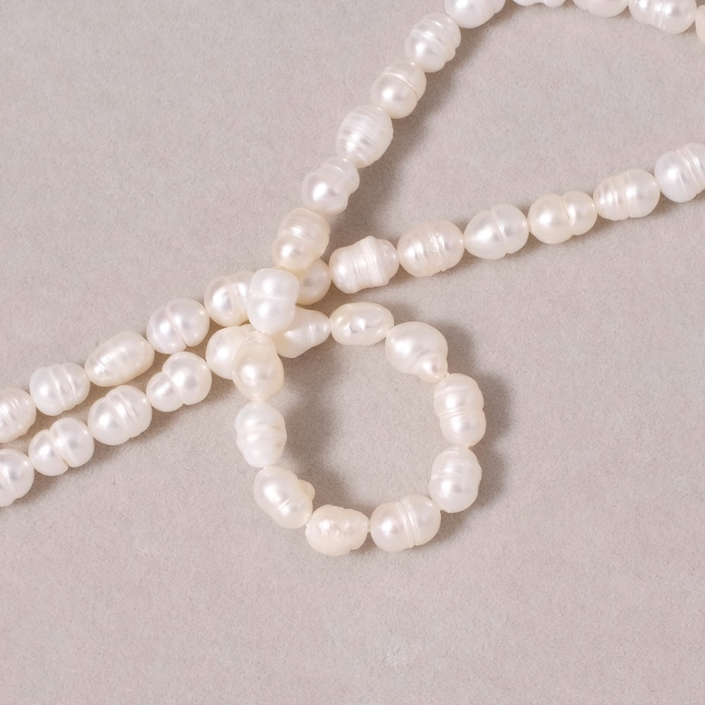 Fil de perles ovales irrégulières en Nacre naturelle blanche