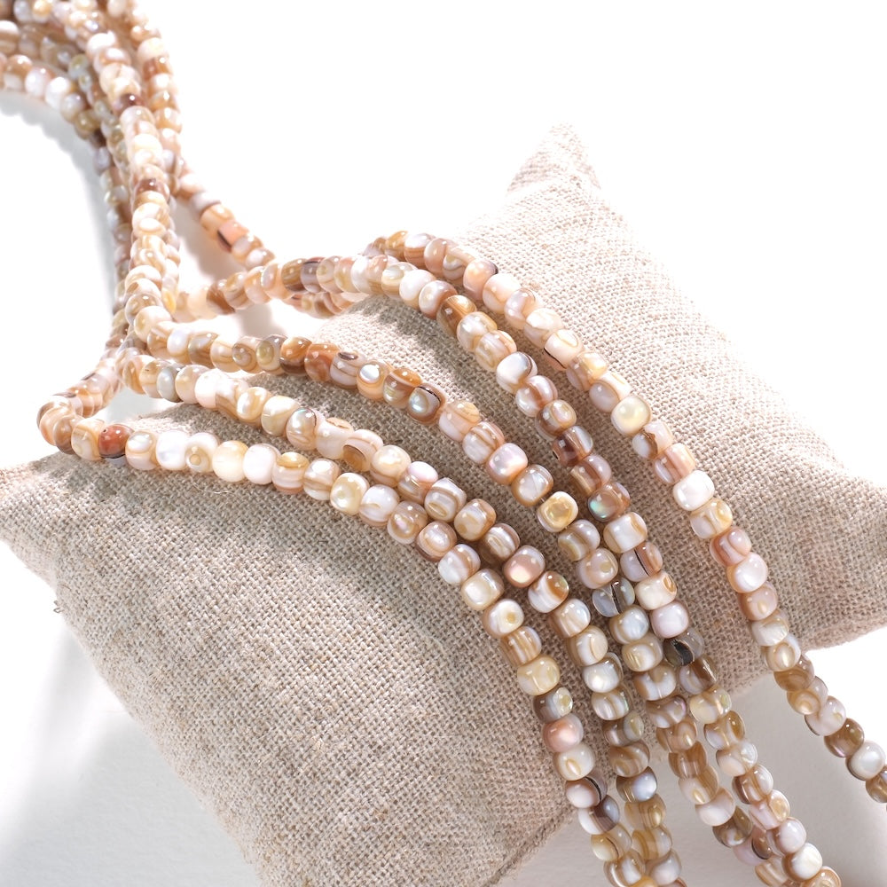 Fils de perles de nacre naturelle d'eau douce sur coussin de lin