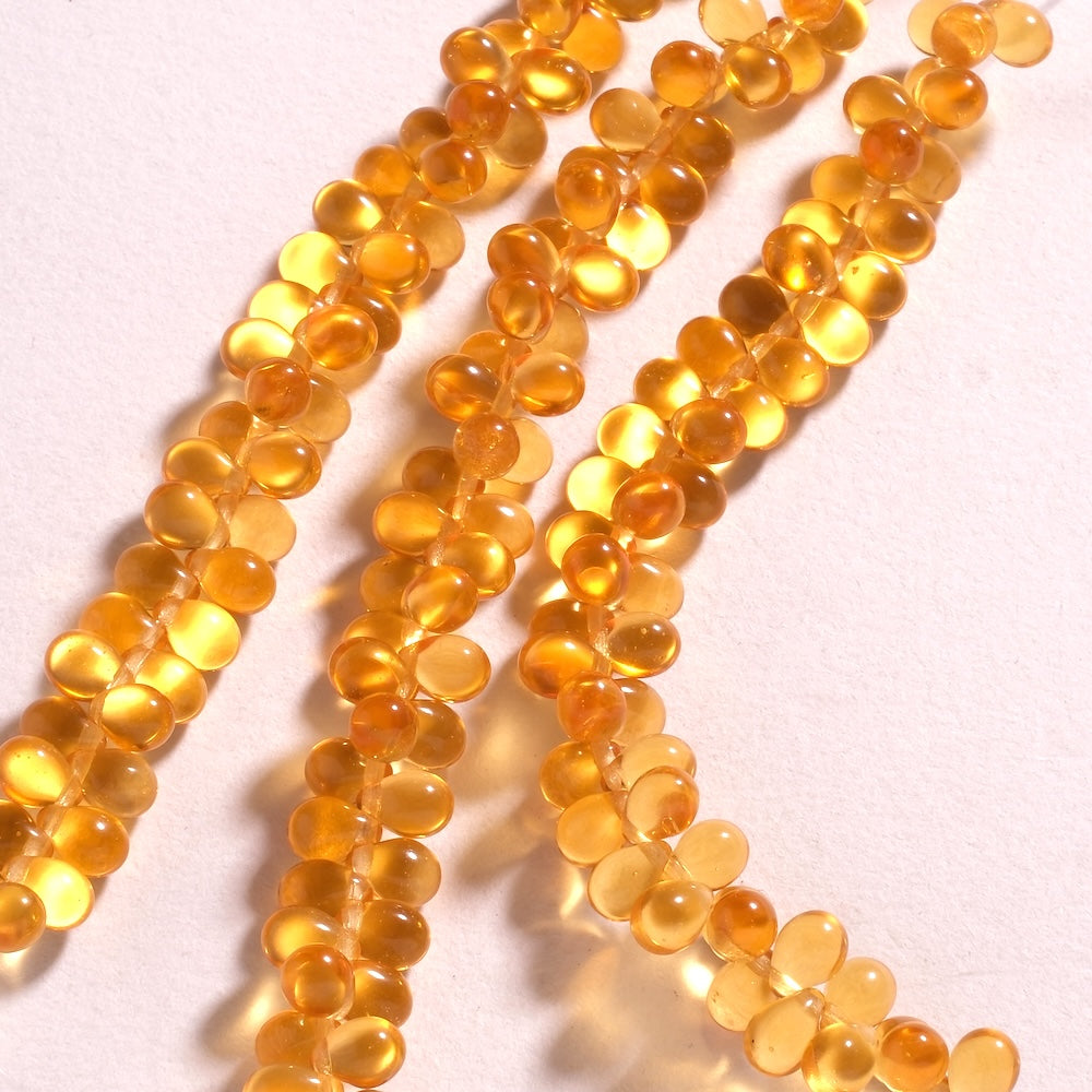 Fil de perles de Bohème gouttes 5 x 7 mm en verre orange doré transparent, percées en tête