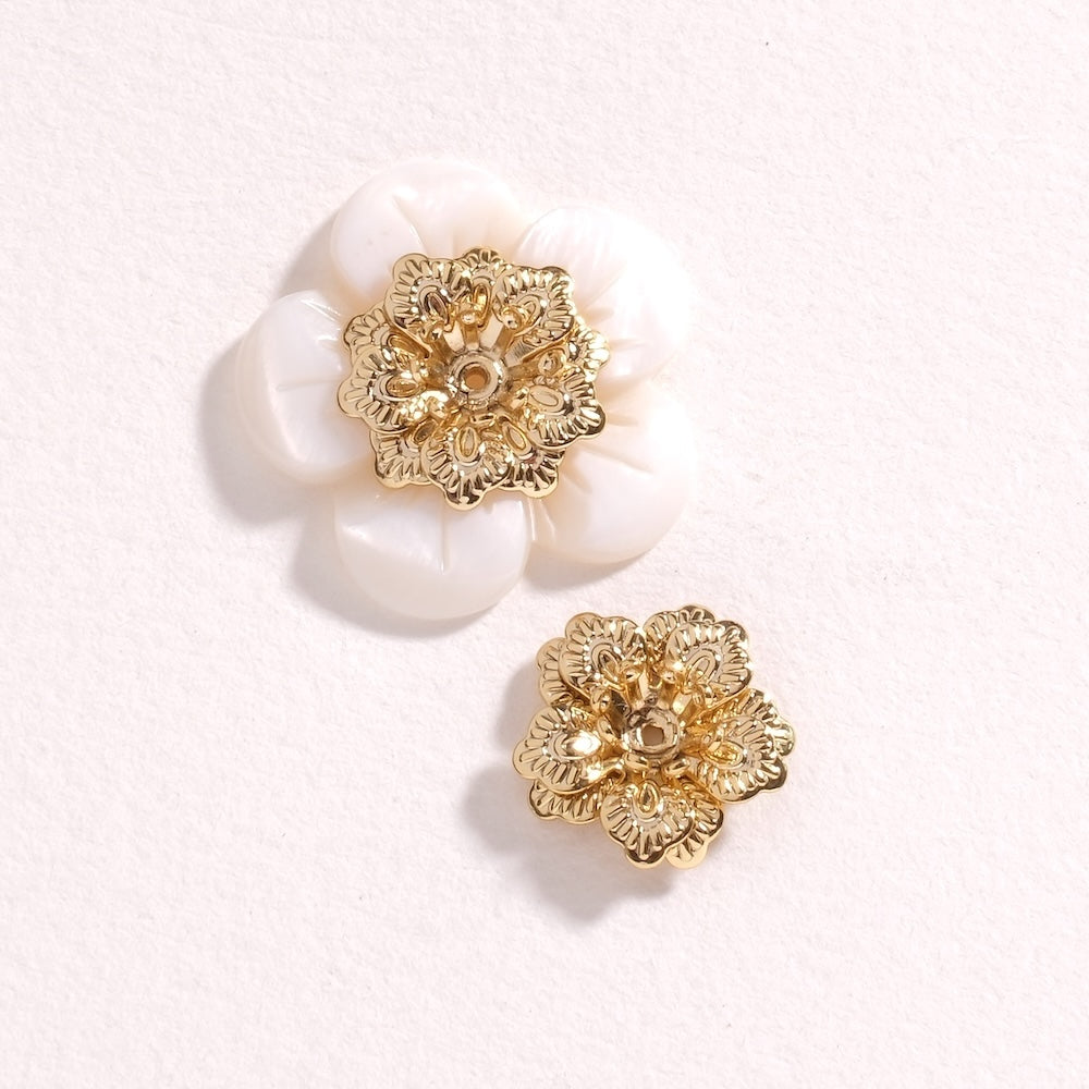 Pendentif fleur coupelle doré 24K posé sur une fleur en nacre blanche